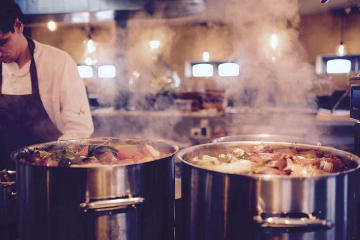 Chef cooking stew in large pots