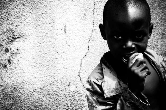 Black and white portrait of a young African child eating