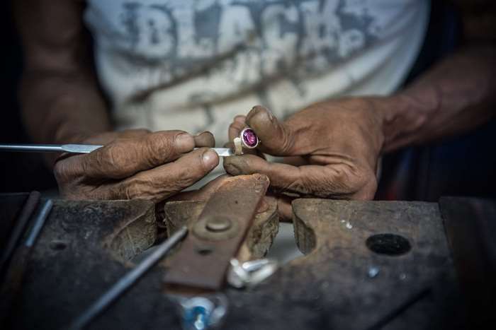 Jeweler working on a ring with a pink gemstone