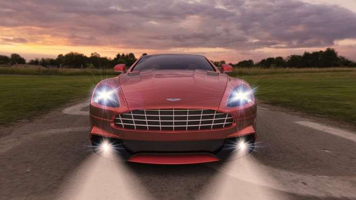 Red Aston Martin driving at sunset