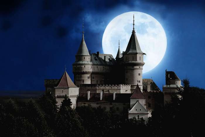 Castle under a full moon at night