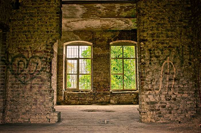 Abandoned brick building interior with windows