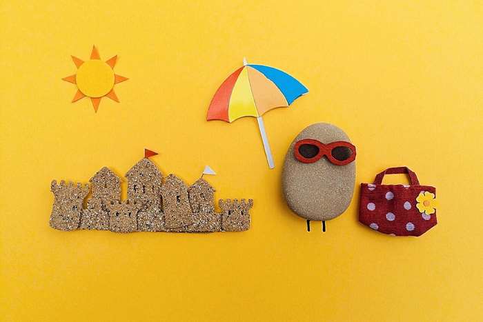 Summer beach scene with sandcastle and rock character