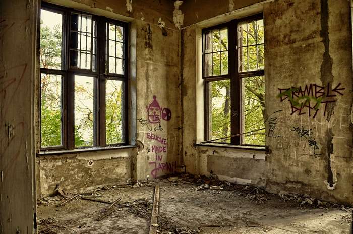 Abandoned building interior with graffiti and broken windows