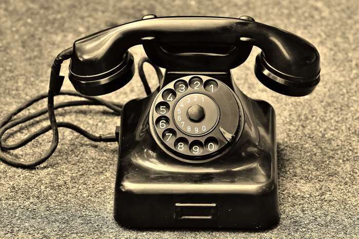 Vintage black rotary dial telephone in sepia