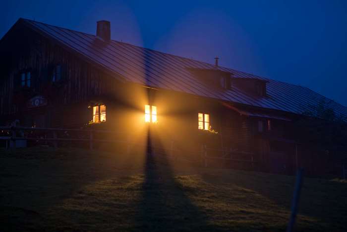 Wooden house with glowing windows at night