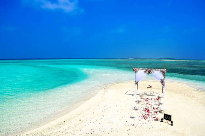 Beach wedding setup on a tropical island with clear blue water