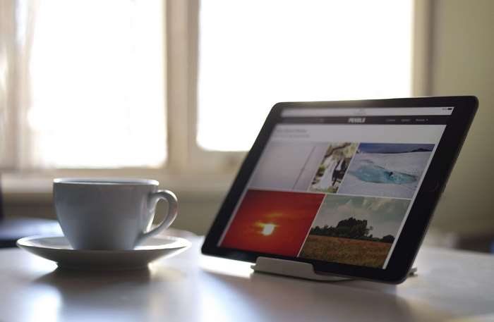 Tablet and coffee cup on a white desk