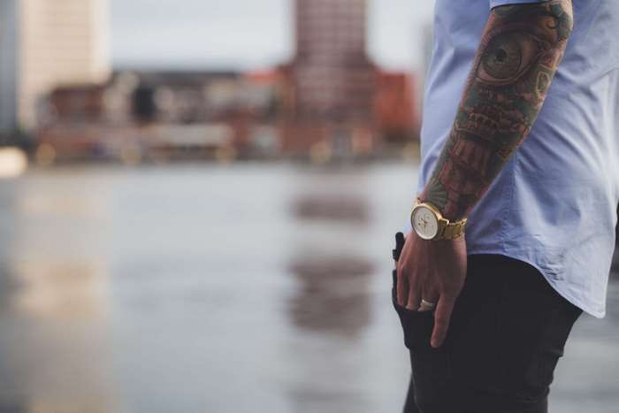 Man with full arm tattoo and watch