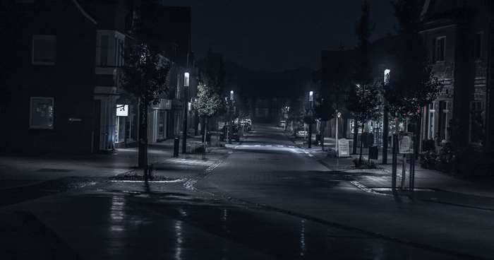 Street at night with wet pavement and streetlights