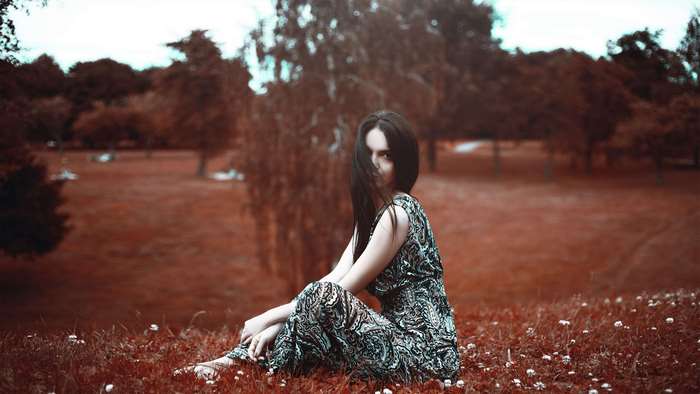 Woman in patterned dress sitting in a park