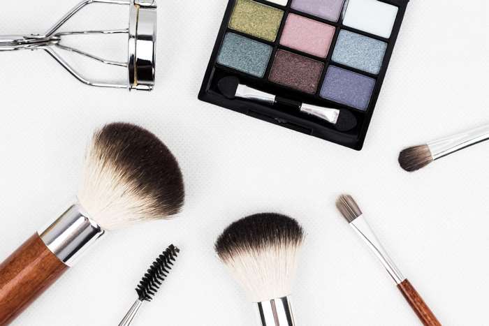 Makeup brushes, eyeshadow palette, and eyelash curler