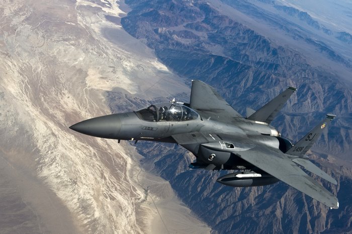 F-15 Eagle fighter jet flying over mountains