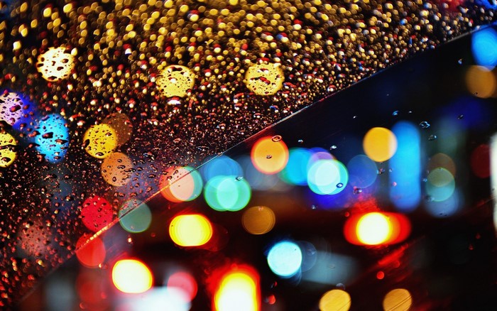 Bokeh lights and raindrops on glass at night