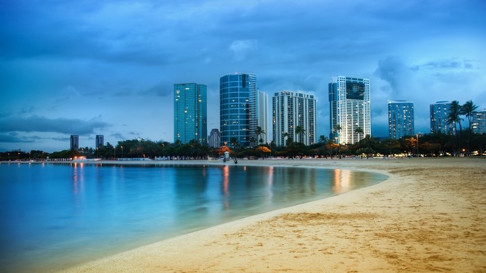 City skyline with skyscrapers on a beach at dusk