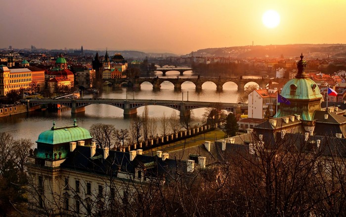 Prague cityscape with bridges over Vltava River at sunset