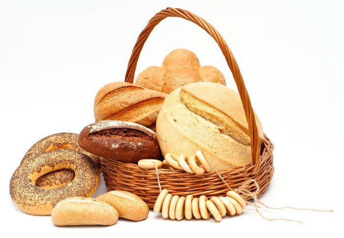 Basket of assorted breads and bagels on white background