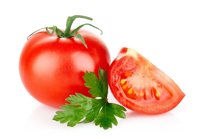 Whole tomato with a slice and parsley