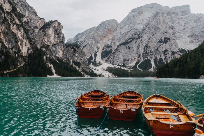 Wooden boats on a turquoise lake with mountains