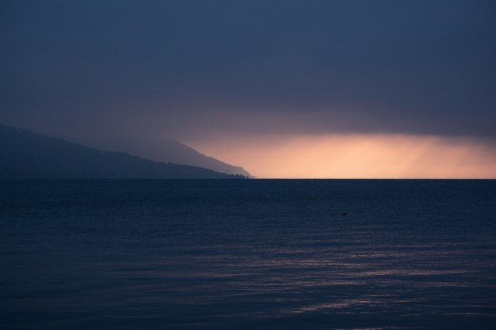 Ocean horizon with clouds and distant mountains