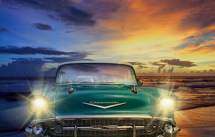 Vintage Chevrolet car on a beach at sunset