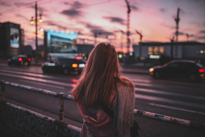 Girl standing on a street at sunset