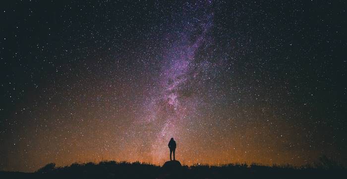 Man standing under the Milky Way galaxy