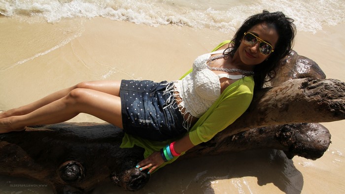 Trisha Krishnan on a beach lying on a log