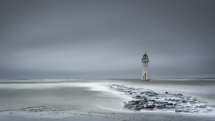 Lighthouse on the ocean with a rocky shore