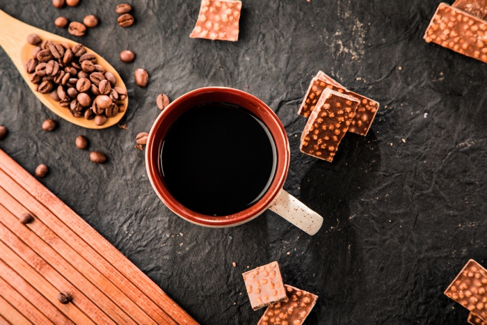 Coffee cup with coffee beans and chocolate pieces