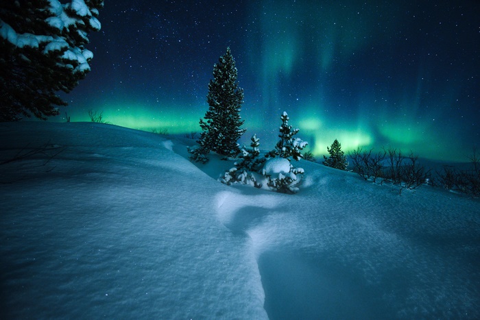 Aurora Borealis over a Snowy Landscape at Night