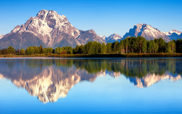 Snow-capped mountains reflected in a calm lake