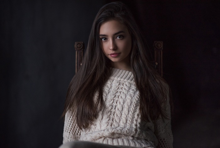 Woman with long black hair wearing a cream sweater