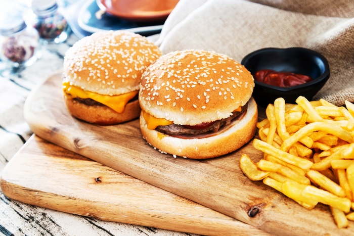 Two cheeseburgers with french fries and ketchup