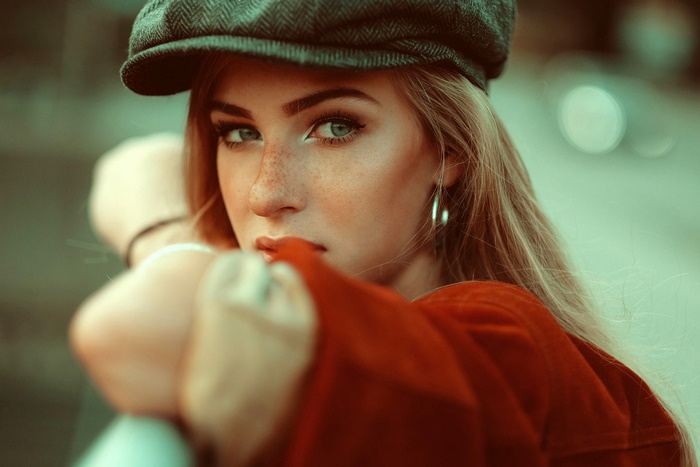 Woman with freckles wearing a cap and red shirt