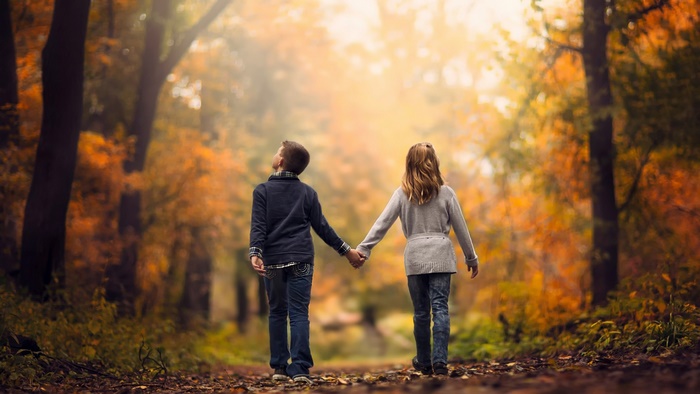 Boy and Girl Holding Hands in Autumn Forest