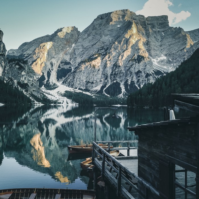 Wooden dock and boats on a mountain lake in Italy