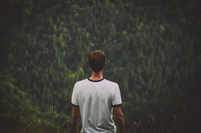Man standing in front of a dense forest