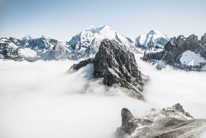 Snow-capped mountains emerging from clouds