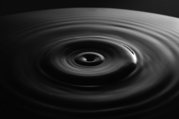 Black and white water drop creating ripples