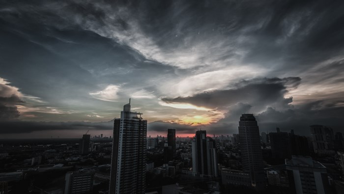 Cityscape with skyscrapers at dusk under cloudy sky