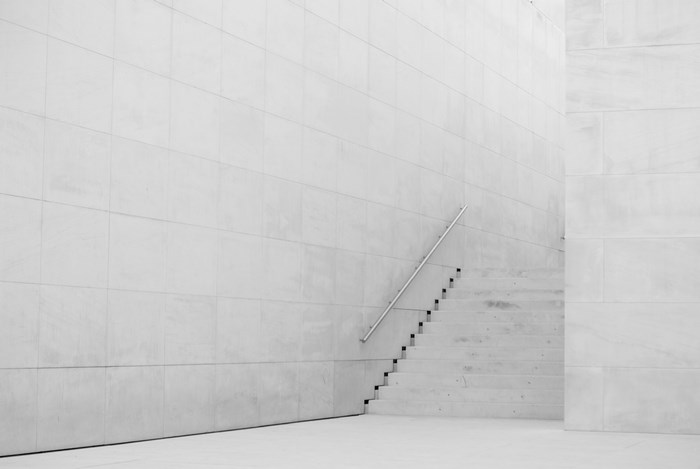 Minimalist white interior with concrete stairs and railing