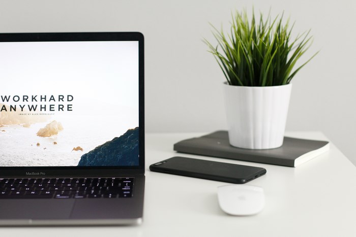 MacBook Pro with potted plant and phone on desk