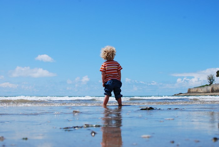 Child wading in the sea on a sunny day