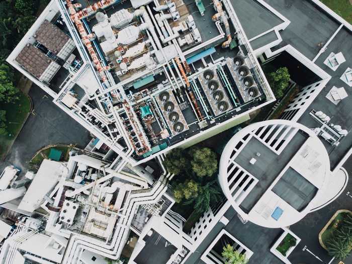 Aerial view of industrial building rooftop with complex piping