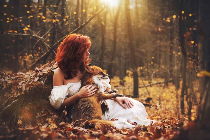 Woman with fox in autumn forest