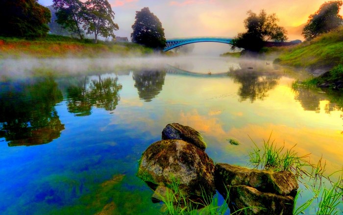 Misty river with bridge and reflections