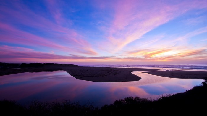 Sunset over a winding river and ocean