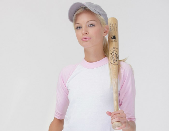 Woman in baseball cap holding Louisville Slugger bat
