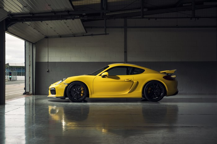 Yellow Porsche Cayman GT4 in a garage